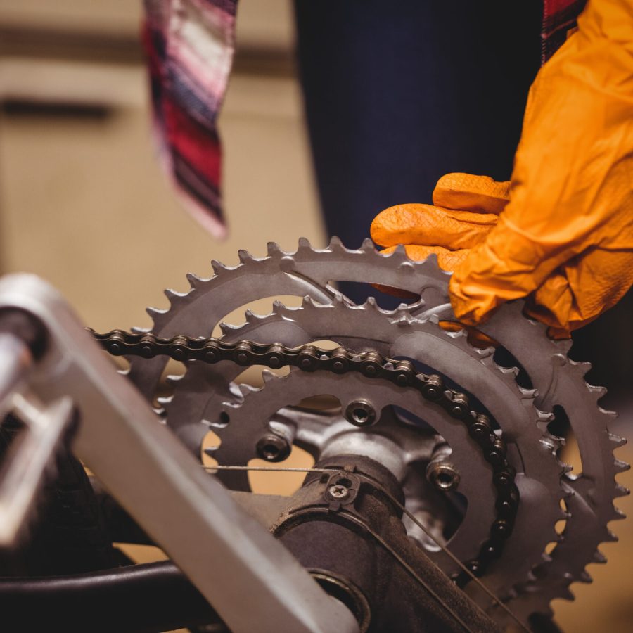 Close-up of mechanic repairing a bicycle in workshop
